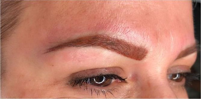 The same eyebrow straight after permanent makeup: an even, softly defined shape.